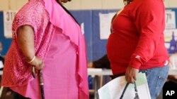 FILE - Two women converse in New York, June 26, 2012. The Food and Drug Administration approved a new version of a popular diabetes medicine for long-term weight management. 