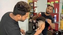 Barber brothers Rajwinder Singh Sidhu, 29, and Gurwinder Singh Sidhu, 31, make a haircut tattoo of Michael Jackson. REUTERS/Sunil Kataria