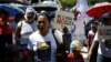 Una mujer sostiene un cartel que dice "El agua no es un negocio" durante una manifestación contra la privatización del agua en San Salvador, El Salvador, el 30 de agosto de 2018. [Foto de archivo]