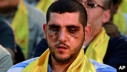 A Hezbollah fighter who was wounded in Qusair, Syria, listens to a speech by Hezbollah leader Sheik Hassan Nasrallah, not shown, during a rally in the southern suburb of Beirut, Lebanon, Friday, June 14, 2013.