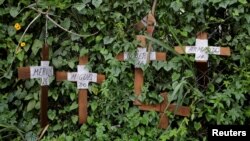 FILE - Cardboard crosses with the names of opposition supporters killed during demonstrations are seen on a fence during a strike called to protest against Venezuelan President Nicolas Maduro's government in Caracas, Venezuela, July 20, 2017. 