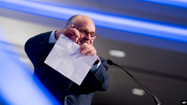 Rudy Giuliani, an attorney for President Donald Trump, pretends to tear a piece of paper as he speaks about the Iran nuclear agreement at the Iran Freedom Convention for Human Rights and Democracy at the Grand Hyatt, May 5, 2018, in Washington.