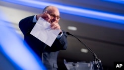 Rudy Giuliani, an attorney for President Donald Trump, pretends to tear a piece of paper as he speaks about the Iran nuclear agreement at the Iran Freedom Convention for Human Rights and Democracy at the Grand Hyatt, May 5, 2018, in Washington.