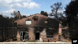 FILE - A burned house is seen in Agios Andreas, east of Athens, July 24, 2018.