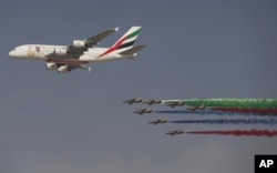 An Emirates Airline A-380 leads the "Al Fursan", or the Knights, a UAE Air Force aerobatic display team, during the opening day of the Dubai Air Show, United Arab Emirates, Nov. 12, 2017.