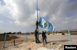 Turkish-backed Free Syrian Army fighters remove the flag of Kurdish security organization Asayish in Kafr Jana village north of Afrin, Syria, March 7, 2018.