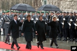 FILE - German Chancellor Angela Merkel, second left, welcomes the President of Egypt, Mohamed Morsi, second right, with military honors at the chancellery in Berlin, Germany, Wednesday, Jan. 30, 2013.