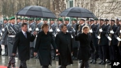 FILE - German Chancellor Angela Merkel, second left, welcomes the President of Egypt, Mohamed Morsi, second right, with military honors at the chancellery in Berlin, Germany, Wednesday, Jan. 30, 2013.