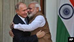 FILE - Indian Prime Minister Narendra Modi, right, hugs Russian President Vladimir Putin before their meeting in New Delhi, India, Oct. 5, 2018.