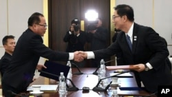 In this photo provided by South Korea, South Korean Vice Unification Minister Chun Hae-sung, right, shakes hands with the head of North Korean delegation Jon Jong Su during a meeting at Panmunjom in the border area between the two Koreas Jan. 17, 2018. (South Korea Unification Ministry via AP)