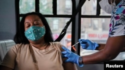 美國紐約市一名婦女接種新冠疫苗（路透社2021年8月18日） 