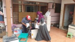 Warga menyelamatkan sisa pakaian dan kelengkapan balita milik mereka pasca banjir bandang melanda Desa Bulukerto yang terletak di Kota Batu, Jawa Timur, pada 11 November 2021. (Foto: VOA/Petrus Riski)