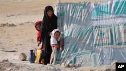 Une Afghane et ses filles dans un camp de déplacés internes en périphérie de Mazar-e-Sharif, le 8 juillet 2021.