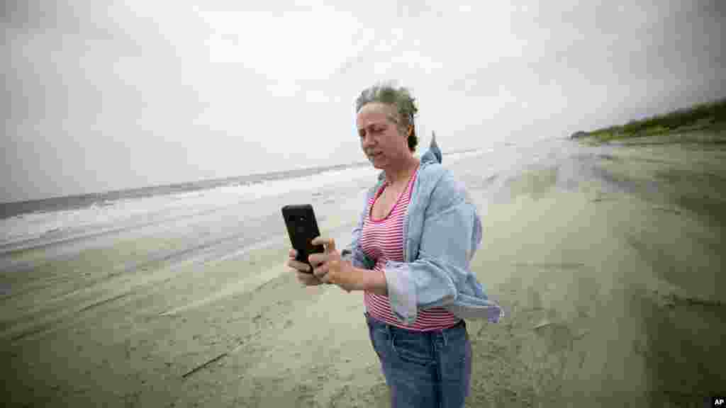 توفان دریایی بعد از فلوریدا، به سمت ایالت های میانی در شرق آمریکا می رود. یک زن در هوای بادی جزیره &laquo;تایبی آیلند&raquo; در جورجیا عکس می گیرد.&nbsp;