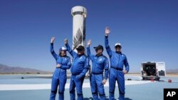 Blue Origin's New Shepard rocket latest space passengers from left, Audrey Powers, William Shatner, Chris Boshuizen, and Glen de Vries raise their hands during a media availability at the spaceport near Van Horn, Texas, Wednesday, Oct. 13, 2021. (AP Photo/LM Otero)