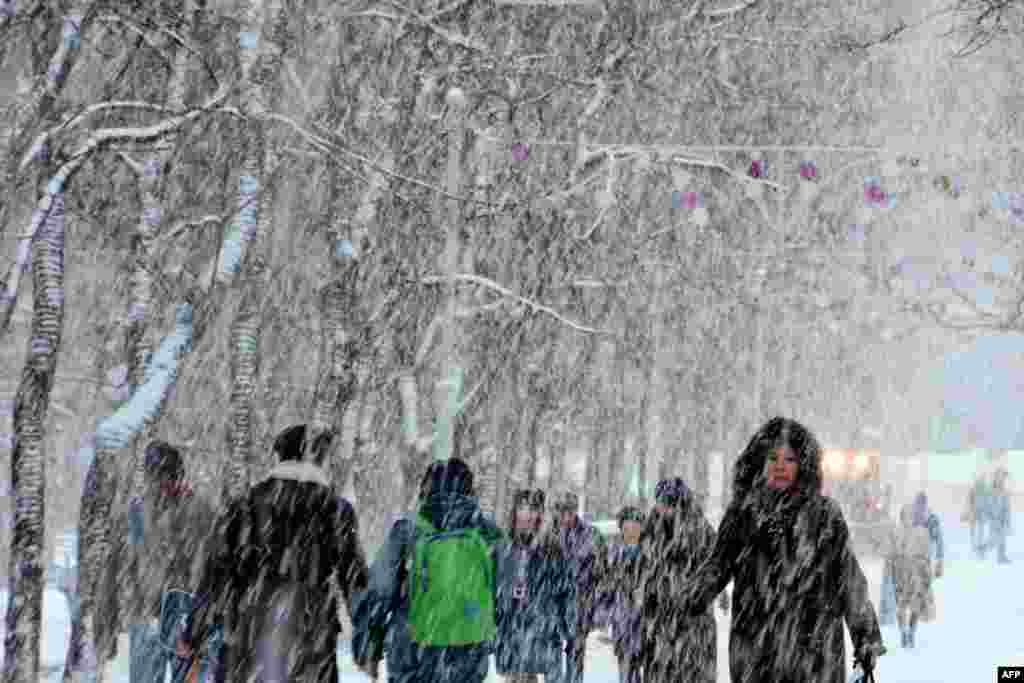 A woman walks along the snow covered Tverskoi Boulevard during a major snowfall in central Moscow, Russia.