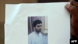  Indian man holds a copy of handout pictures released by the police showing Indian Mujahideen operative and alleged mastermind of the July 2011 Mumbai serial blasts, Yasin Bhatkal, at a press conference in Mumbai.