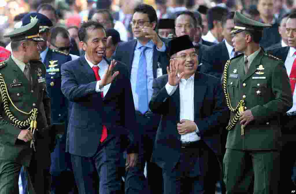 Indonesia's President Joko Widodo walks with his Vice President Jusuf Kalla in Jakarta, Indonesia, Oct. 20, 2014.