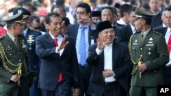 Indonesia's President Joko Widodo walks with his Vice President Jusuf Kalla in Jakarta, Indonesia, Oct. 20, 2014.