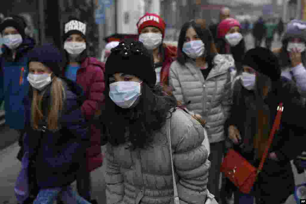 Sekelompok anak-anak sekolah berjalan mengenakan masker penutup hidung dan mulut di Sarajevo, Bosnia. Akibat polusi yang bercampur dengan kabut, pemerintah Sarajevo mengatakan mereka menutup sekolah-sekolah di kota sementara para sukarelawan mulai membagikan masker penutup hidung dan mulut kepada mereka yang masih memutuskan untuk tidak keluar rumah walaupun para ahli telah memperingatkan mereka.