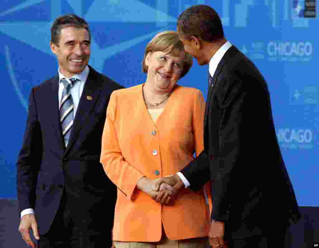 German Chancellor Angela Merkel talks to President Barack Obama as she arrives in Chicago, Sunday, May 20, 2012. At left is NATO Secretary General Anders Fogh Rasmussen. (AP)