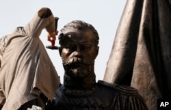 FILE - A worker prepares a new statue of Russia's last Czar, Nicholas II, in downtown Belgrade, Serbia, Oct. 13, 2014. Moscow has been slowly losing its clout in Eastern Europe, as countries have joined NATO and the EU.