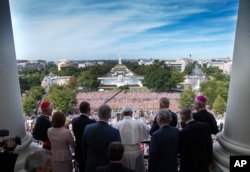 Pope Francis, accompanied by members of Congress, waves to the crowd from the Speakers Balcony on Capitol Hill in Washington, Sept. 24, 2015, after addressing a joint meeting of Congress inside.