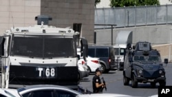 Seorang polisi berjaga di dekat kendaraan berlapis baja di luar gedung pengadilan di Istanbul, Turki, 15 Agustus 2016 (Foto: dok). Pihak berwenang memerintahkan penahanan 73 pilot Angkatan Udara yang dituduh menjadi bagian dari upaya kudeta Juli lalu yang gagal.