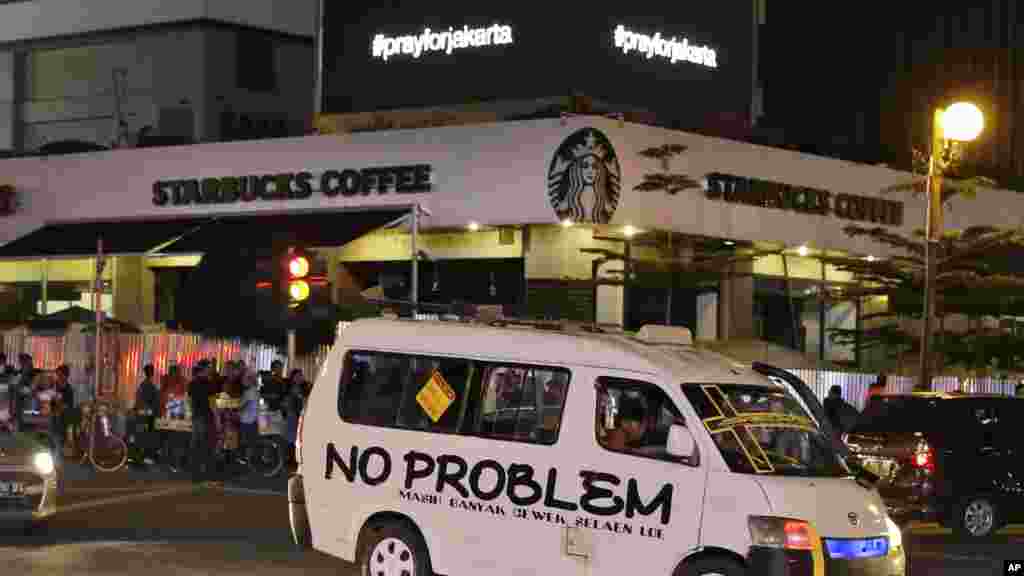 An electronic screen above the Starbucks cafe where an attack took place displays the message "Pray for Jakarta" showing support for the city in Jakarta, Indonesia, Thursday, Jan. 14, 2016. Attackers set off bombs and exchanged gunfire outside the cafe in Indonesia's capital in a brazen assault Thursday that police said "imitated" the recent Paris attacks.