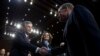 Senate Intelligence Committee Vice Chairman Mark Warner, D-Va., shake hands with FBI Director Christopher Wray as CIA Director Gina Haspel looks on before the Senate Intelligence Committee hearing on Capitol Hill in Washington, Jan. 29, 2019. 