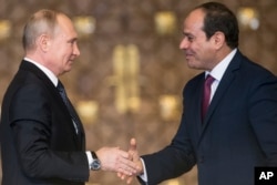 Russian President Vladimir Putin, left, Egyptian President Abdel-Fattah El-Sissi, shake hands after a news conference following their talks in Cairo, Egypt, Dec. 11, 2017.