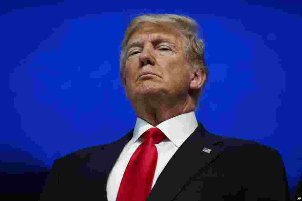 President Donald Trump listens as he is introduced to deliver a speech to the World Economic Forum.