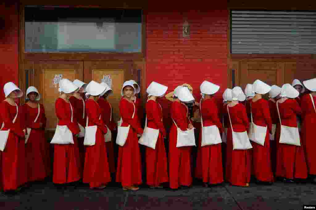 Women dressed as handmaids promoting the Hulu original series &quot;The Handmaid&#39;s Tale&quot; stand along a public street during the South by Southwest (SXSW) Music Film Interactive Festival 2017 in Austin, Texas, USA, March 11, 2017.