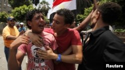8일 이집트 군부가 무르시 대통령을 지지하는 무슬림형제단 시위대에 발포한 가운데, 총격으로 동료를 잃은 시위대 일원이 오열하고 있다.
