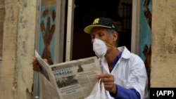 Un hombre se protege de coronavirus en La Habana, Cuba, mientras lee un periódico el 12 de marzo de 2020.