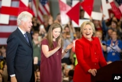 Democratic presidential candidate Hillary Clinton, accompanied by former President Bill Clinton and their daughter, Chelsea Clinton, arrives at her caucus night rally at Drake University in Des Moines, Iowa, Feb. 1, 2016.