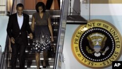 President Barack Obama and first lady Michelle Obama arrive at Chicago O'Hare International Airport to attend the NATO Summit, Saturday, May 19, 2012 in Chicago.