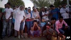 FILE - Eritrean migrants mourn during a memorial gathering for Habtom Zarhum, in Tel Aviv, Israel, Oct. 21, 2015. Zarhum died of his wounds after an Israeli security guard fired at him and later was beaten by a mob that mistakenly believed he was a Palestinian attacker during a shooting in the southern city of Beersheba.