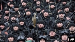 FILE - Chechen special forces listen to Chechnya's regional leader Ramzan Kadyrov (unseen) deliver a speech in Chechnya's capital of Grozny, Russia, Dec. 28, 2014. Some experts believe, if Russia is deploying Chechen forces to Syria, then it is doing so as casualties among Chechens would not cause the same alarm among the general Russian population as deaths of ethnic Russians would.