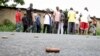 A man takes a picture of spent bullet casings lying on a street in the Nyakabiga neighborhood of Bujumbura, Burundi, Dec. 12, 2015. The country has been in a yearlong crisis, which grew out of President Pierre Nkurunziza's decision to seek a third term in office.