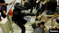 Polisi bentrok dengan beberapa demonstran saat menyerbu sebuah mal di Hong Kong, Minggu (3/11). 