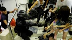 La gente se pelea con un agente de la policía antidisturbios en un centro comercial el domingo en Tai Po en Hong Kong.