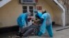 Para tenaga medis mengangkat pria yang terjatuh di luar Rumah Sakit Umum ke kursi roda untuk dibawa ke ruang gawat darurat bagi pasien Covid-19 di La Paz, Bolivia, 23 Juli 2020. (Foto: AP)