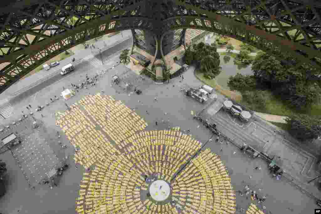 Thousands of participants dressed performing yoga on yellow mattresses are pictured from the first floor of the Eiffel Tower at an event to celebrate the International Yoga Day in Paris, France.
