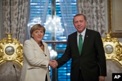 Turkish President Recep Tayyip Erdogan, right, shakes hands Germany's Chancellor Angela Merkel, left, following a joint statement after their meeting in Istanbul, Oct. 18, 2015.