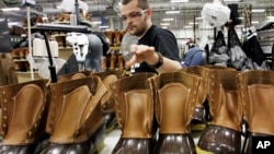 FILE - Eric Rego stitches boots in the facility where L.L. Bean boots are assembled in Brunswick, Maine, Dec. 14, 2011.