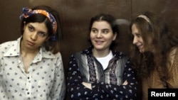 Nadezhda Tolokonnikova (L), Yekaterina Samutsevich (C) and Maria Alyokhina, members of female punk band 'Pussy Riot,' attend their trial in a court in Moscow, August 3, 2012.