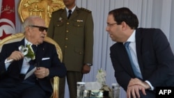 Le président tunisien Béji Caïd Essebsi, à gauche, et le Premier ministre Youssef Chahed assistent au forage militaire des forces navales tunisiennes, au port de La Goulette, à l'occasion du 62ème anniversaire de l'armée nationale, Tunis, le 25 juin 2018.