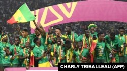 FILE: Senegal's players celebrate after winning the Africa Cup of Nations (AFCON) 2021 final football match between Senegal and Egypt at Stade d'Olembe in Yaounde on February 6, 2022. 