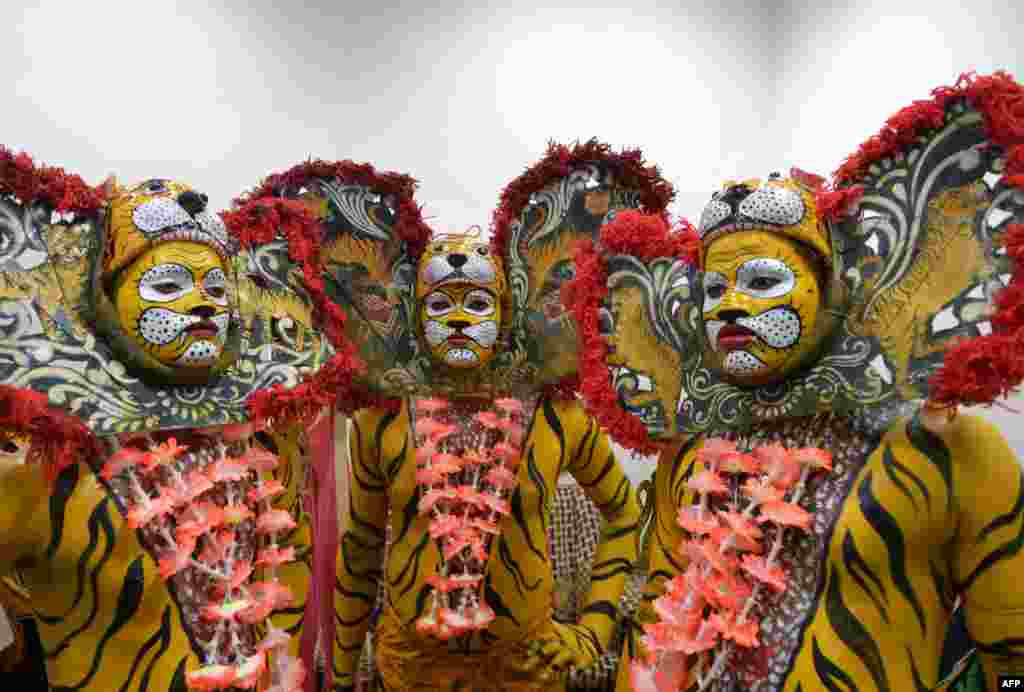 Indian tribal dancers dressed in costume prepare to perform a traditional 'tiger dance' on the occasion of International Tiger Day in Kolkata.